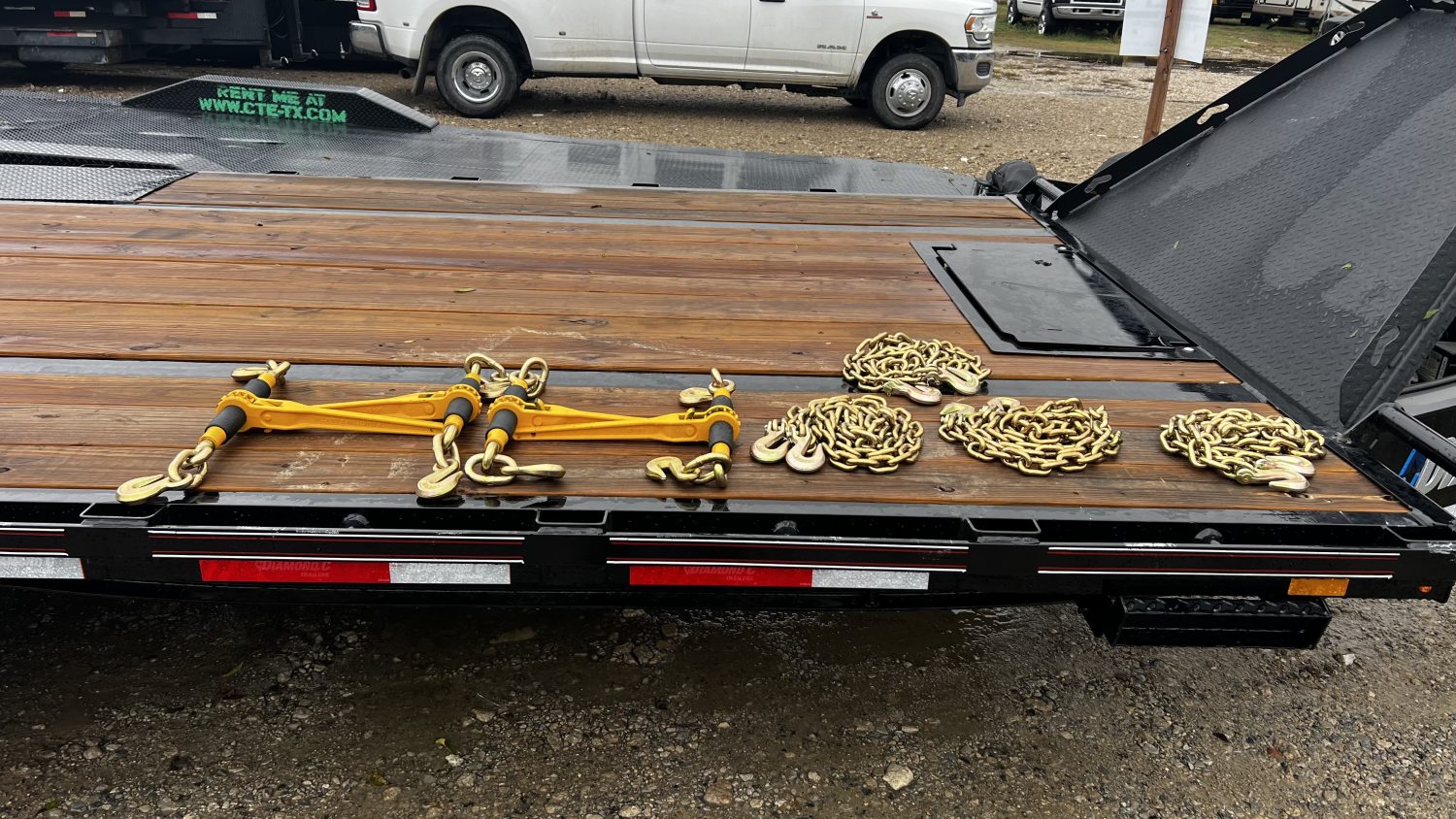 Chain binders and chains on 22ft Diamond C deck-over tilt trailer rental in McKinney TX